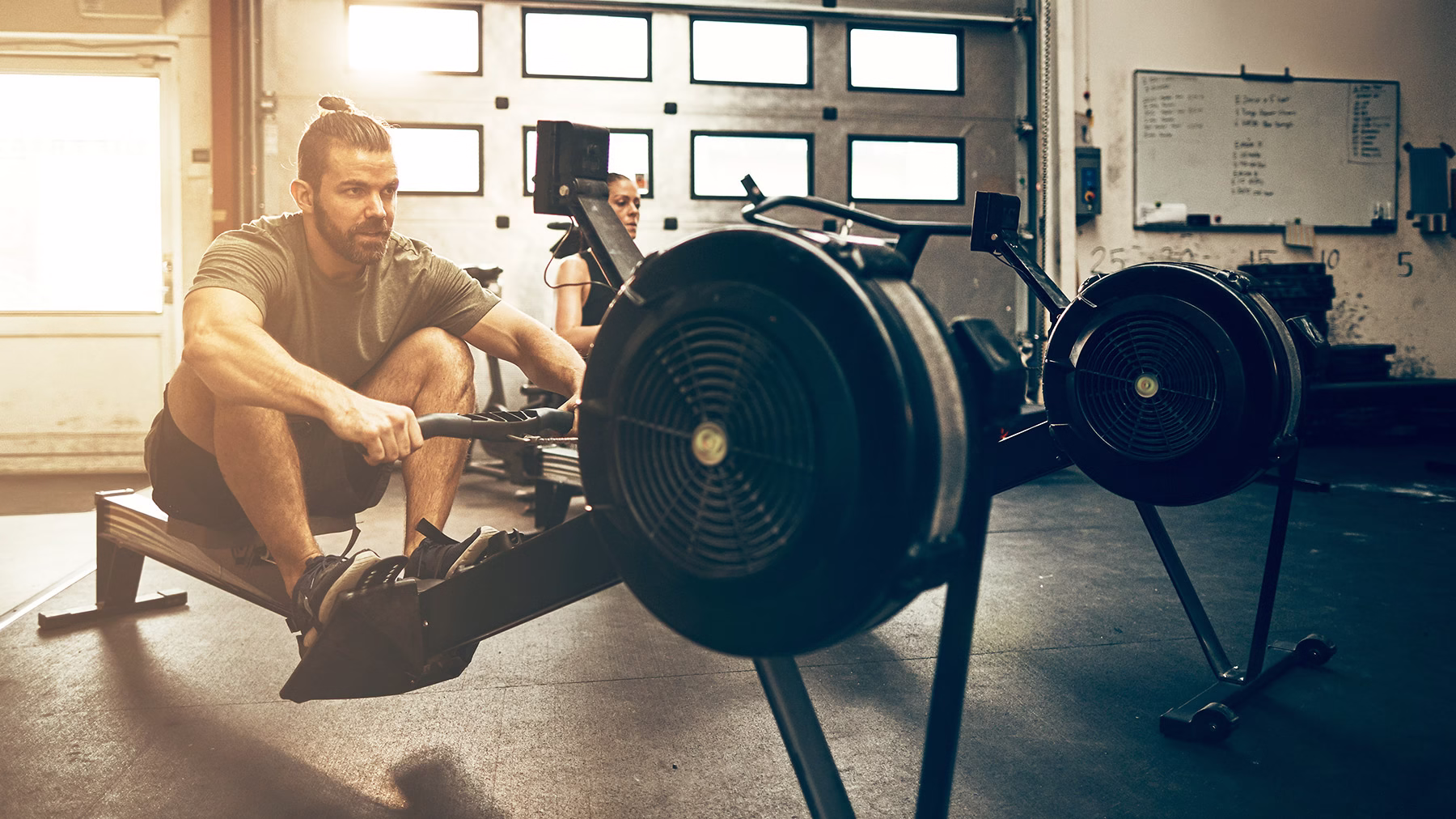 Buy the best gym equipment and apparel at Rogue Fitness. Couple working out in gym with Concept2 rowers sold at Rogue Fitness.